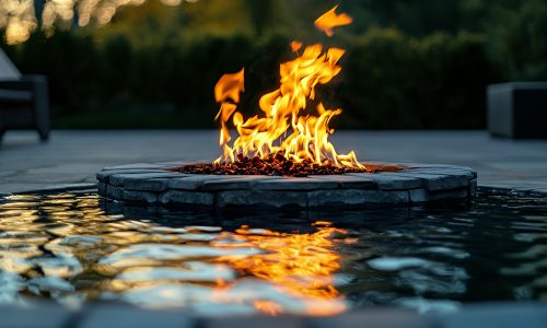 A close-up view of a fire pit with flames reflecting in the water.